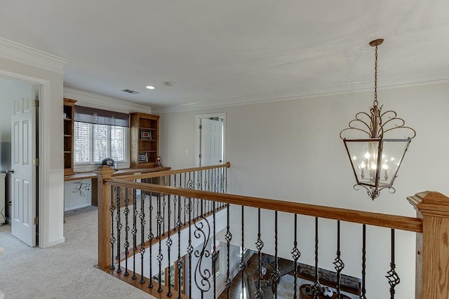 hallway with an inviting chandelier, crown molding, and carpet floors