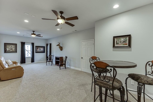 carpeted dining room with ceiling fan