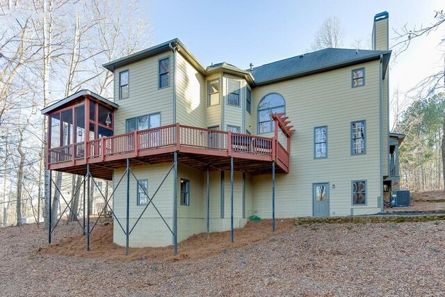 rear view of house featuring cooling unit, a deck, and a sunroom