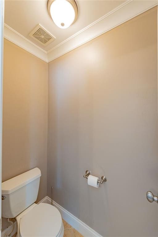 bathroom featuring tile patterned flooring, toilet, and crown molding