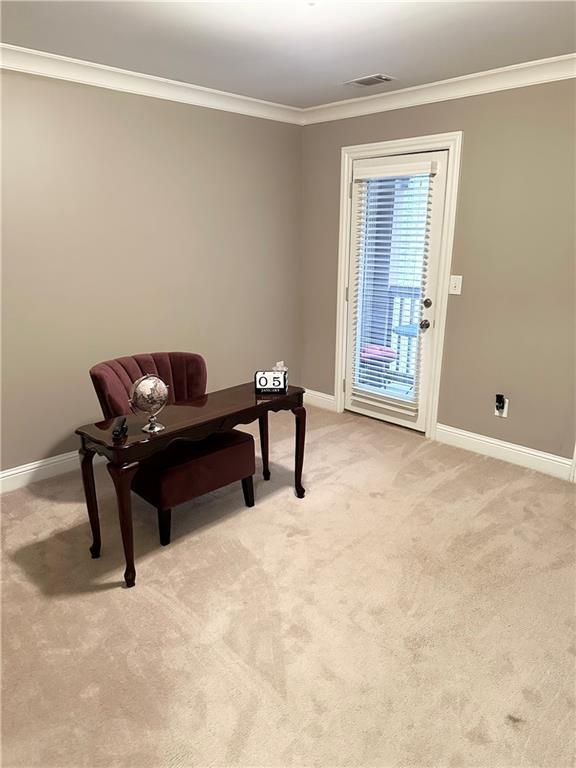 living area featuring light colored carpet and crown molding