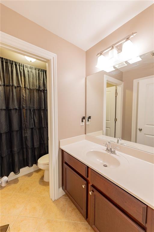 bathroom with tile patterned flooring, vanity, and toilet