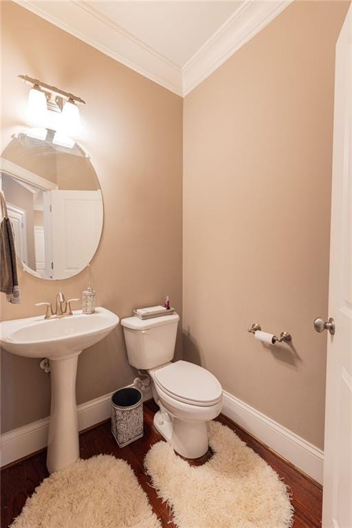 bathroom featuring crown molding, hardwood / wood-style floors, sink, and toilet