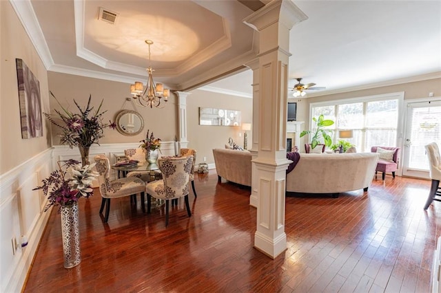 dining space with a tray ceiling, crown molding, dark hardwood / wood-style flooring, and ceiling fan with notable chandelier