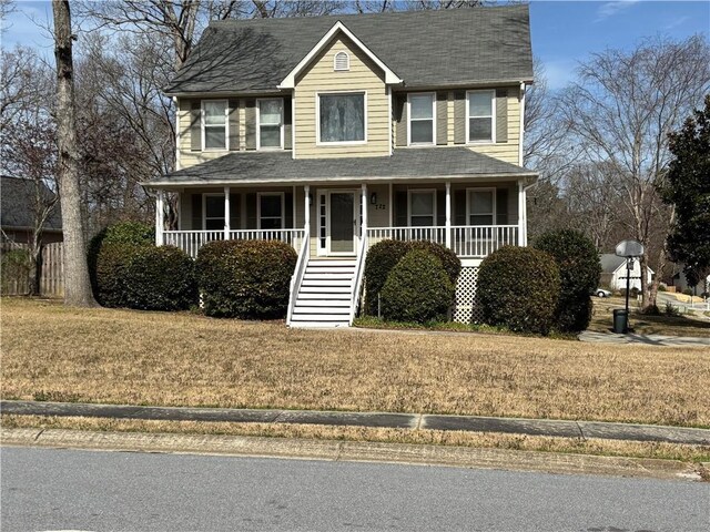 view of front of home featuring stairs, a front lawn, a porch, and roof with shingles