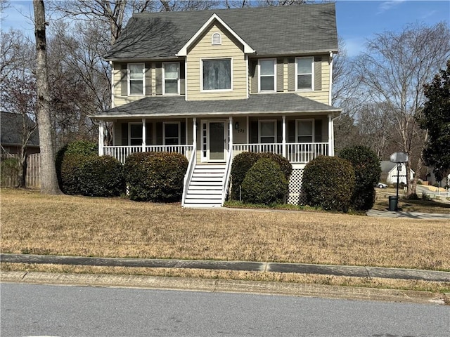 view of front facade with stairs, a porch, a front yard, and a shingled roof