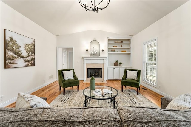 sitting room featuring lofted ceiling, light wood-type flooring, baseboards, and a fireplace with flush hearth