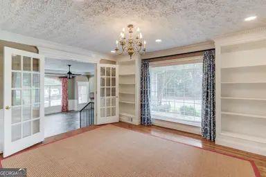 unfurnished dining area with a textured ceiling, plenty of natural light, and french doors