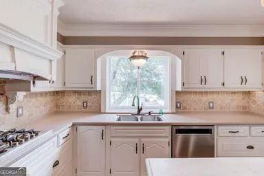kitchen with a sink, light countertops, white cabinets, and stainless steel appliances