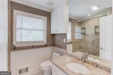 full bathroom with visible vents, a shower stall, and plenty of natural light