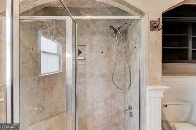 full bathroom with toilet and a shower stall