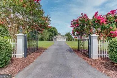 view of street with a gate, a gated entry, and aphalt driveway