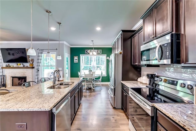 1412 Chapman Cir, Monroe, GA 30656 - kitchen featuring stainless steel appliances, dark brown cabinets, light stone countertops, ornamental molding, and light wood finished floors