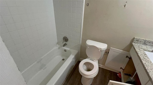 full bathroom with vanity, hardwood / wood-style flooring, toilet, and tiled shower / bath combo