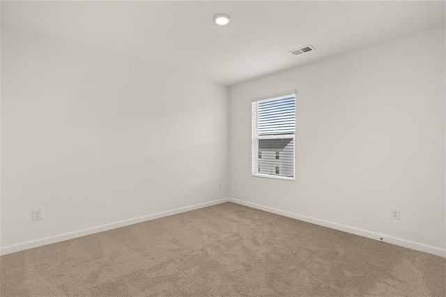 spare room featuring light colored carpet