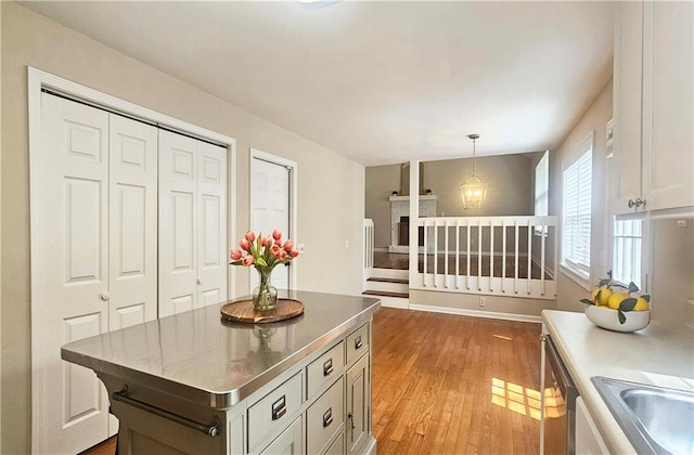 5415 Keithwood Dr, Cumming, GA 30040 - kitchen with light wood-style floors, stainless steel dishwasher, a center island, stainless steel countertops, and hanging light fixtures