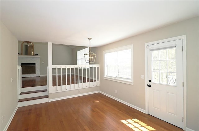 5415 Keithwood Dr, Cumming, GA 30040 - foyer entrance featuring baseboards, a notable chandelier, wood finished floors, and a high end fireplace