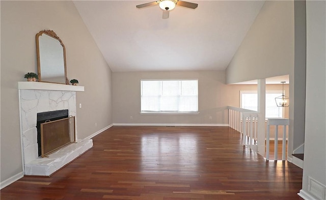 5415 Keithwood Dr, Cumming, GA 30040 - unfurnished living room featuring ceiling fan with notable chandelier, a fireplace with raised hearth, visible vents, wood finished floors, and lofted ceiling