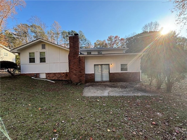 rear view of house featuring a yard and a patio