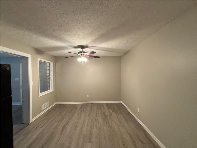 empty room with wood-type flooring, a textured ceiling, and ceiling fan