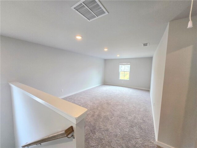 empty room featuring carpet, visible vents, baseboards, and recessed lighting