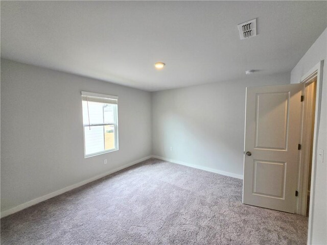 unfurnished room featuring light colored carpet