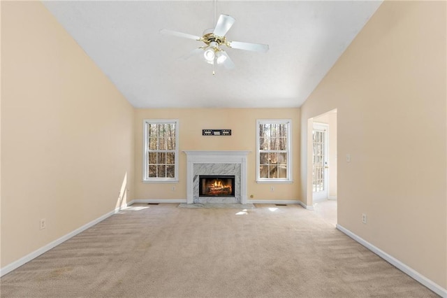 unfurnished living room with light colored carpet, a fireplace, a ceiling fan, baseboards, and vaulted ceiling