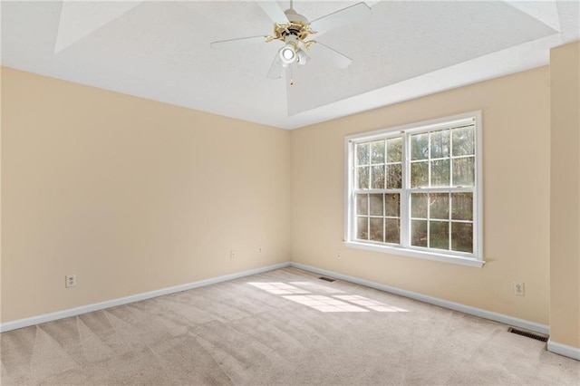 carpeted empty room featuring baseboards, visible vents, and ceiling fan