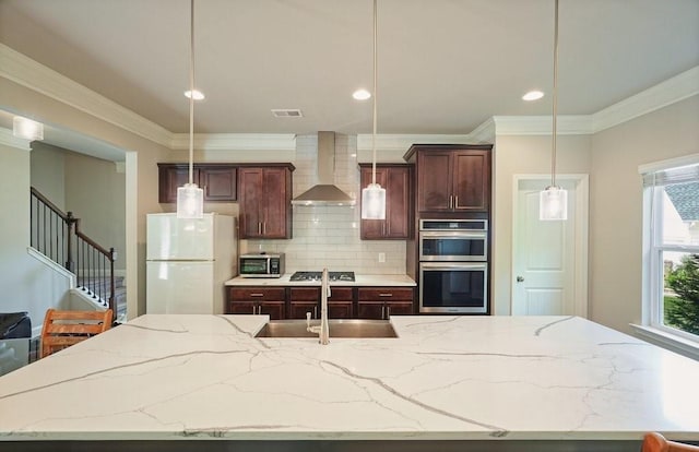 1630 Eaglerock Dr, Suwanee, GA 30024 - kitchen with wall chimney range hood, stainless steel appliances, a center island with sink, ornamental molding, and backsplash