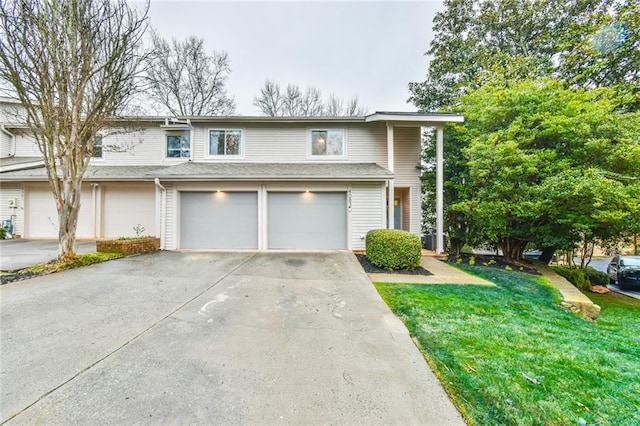 view of property with a garage and a front lawn