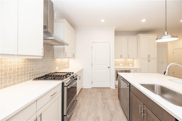 707 Dodd Ln N Unit 164, Buford, GA 30518 - kitchen featuring appliances with stainless steel finishes, wall chimney range hood, a sink, white cabinetry, and light countertops