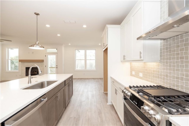 707 Dodd Ln N Unit 164, Buford, GA 30518 - kitchen with wall chimney exhaust hood, stainless steel appliances, a sink, light countertops, and white cabinetry