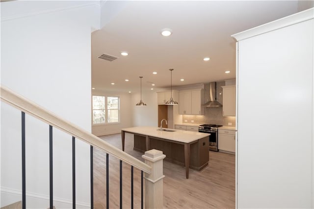 707 Dodd Ln N Unit 164, Buford, GA 30518 - kitchen featuring stainless steel gas range, wall chimney range hood, a sink, recessed lighting, and tasteful backsplash