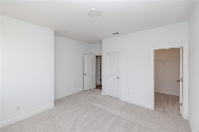 707 Dodd Ln N Unit 164, Buford, GA 30518 - unfurnished bedroom with light carpet, baseboards, a walk in closet, and a closet
