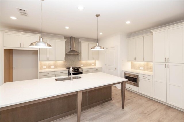 707 Dodd Ln N Unit 164, Buford, GA 30518 - kitchen featuring wall chimney range hood, tasteful backsplash, stainless steel range with gas stovetop, white cabinets, and decorative light fixtures