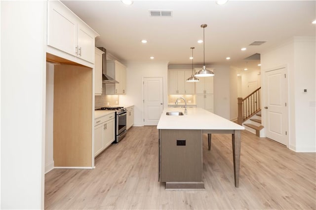 707 Dodd Ln N Unit 164, Buford, GA 30518 - kitchen featuring stainless steel gas range oven, a sink, decorative backsplash, a center island with sink, and recessed lighting