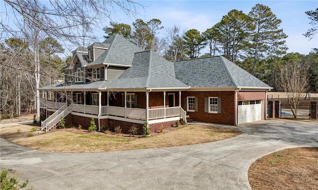 view of front of house with a garage, covered porch, and a front yard