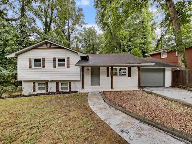 split level home with a garage, a porch, and a front lawn