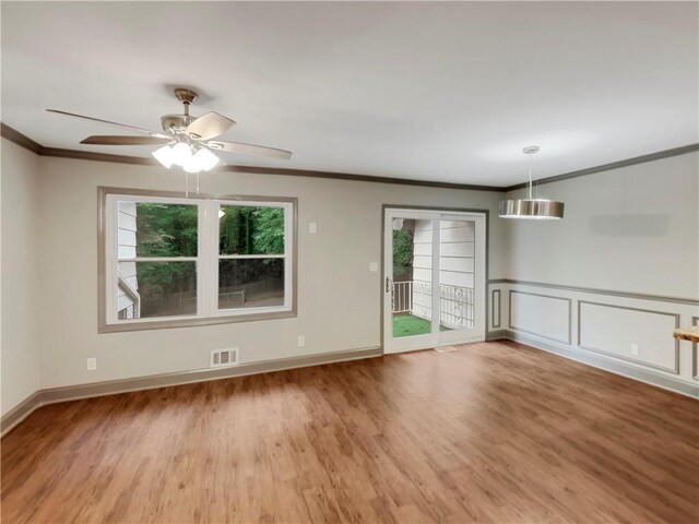 unfurnished room featuring ceiling fan, crown molding, hardwood / wood-style floors, and a wealth of natural light