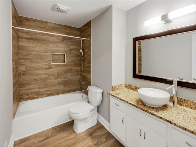 full bathroom featuring tiled shower / bath combo, vanity, toilet, and hardwood / wood-style flooring