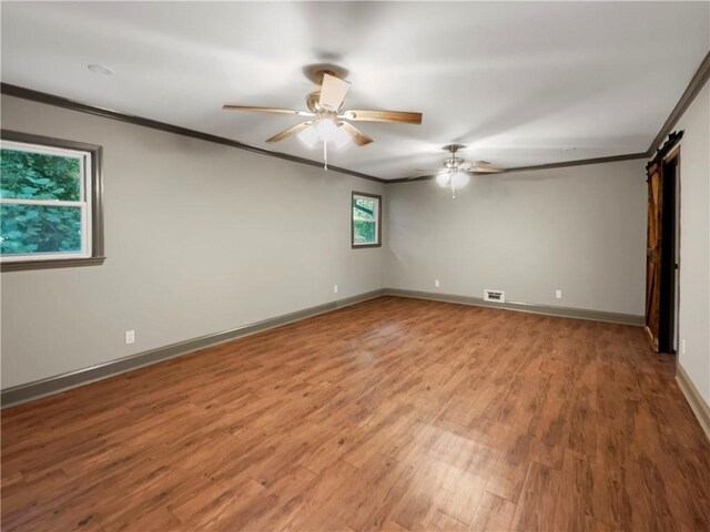 spare room with wood-type flooring, ceiling fan, and a wealth of natural light