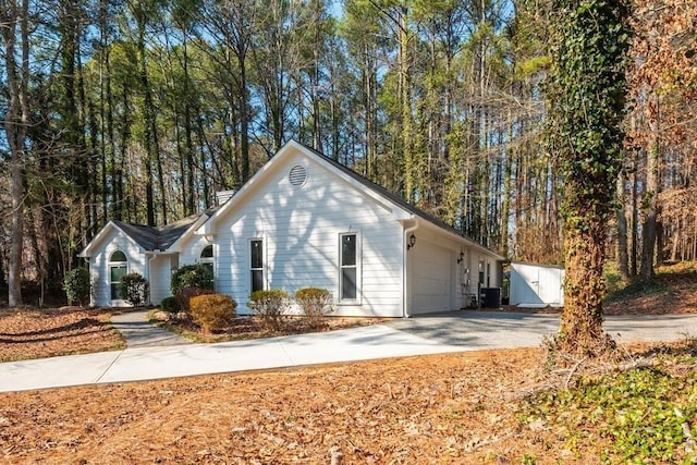 6060 Carriage Dr, Cumming, GA 30028 - view of property exterior featuring driveway, a garage, and central AC unit