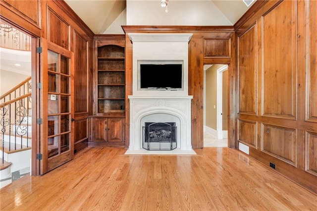 unfurnished living room featuring light wood-type flooring and lofted ceiling