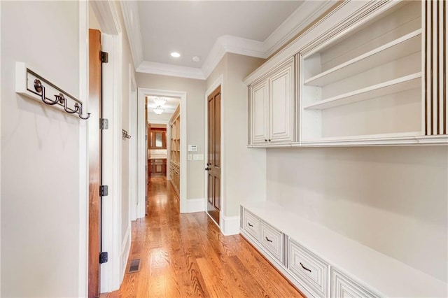 corridor featuring light hardwood / wood-style floors and ornamental molding