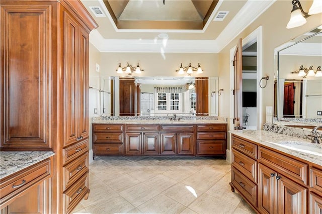 bathroom with tile patterned flooring, vanity, a raised ceiling, and crown molding