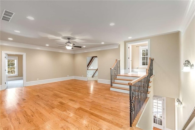 unfurnished room featuring a wealth of natural light, ceiling fan, light hardwood / wood-style floors, and ornamental molding