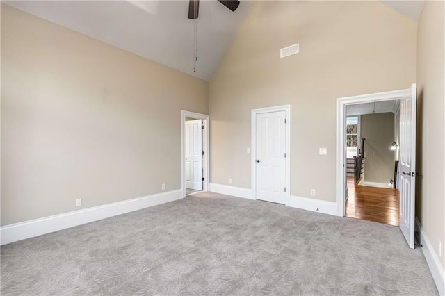 unfurnished bedroom featuring ceiling fan, light colored carpet, and high vaulted ceiling