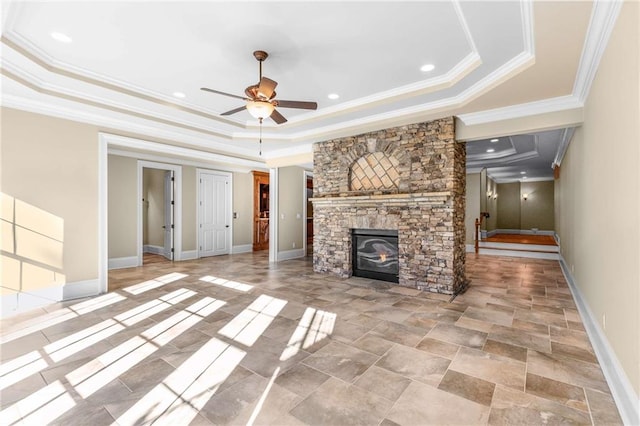 unfurnished living room with a fireplace, a raised ceiling, ceiling fan, and ornamental molding