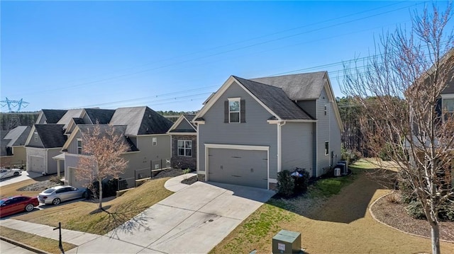 traditional-style home featuring an attached garage, central AC, and driveway