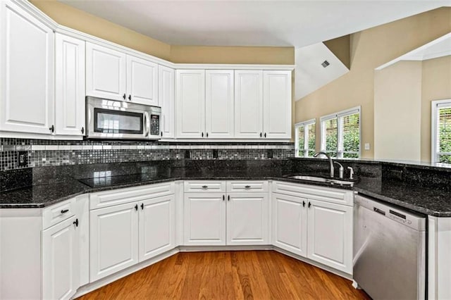 2709 Windrush Dr, Buford, GA 30518 - kitchen featuring stainless steel appliances, a sink, a peninsula, light wood-style floors, and white cabinets